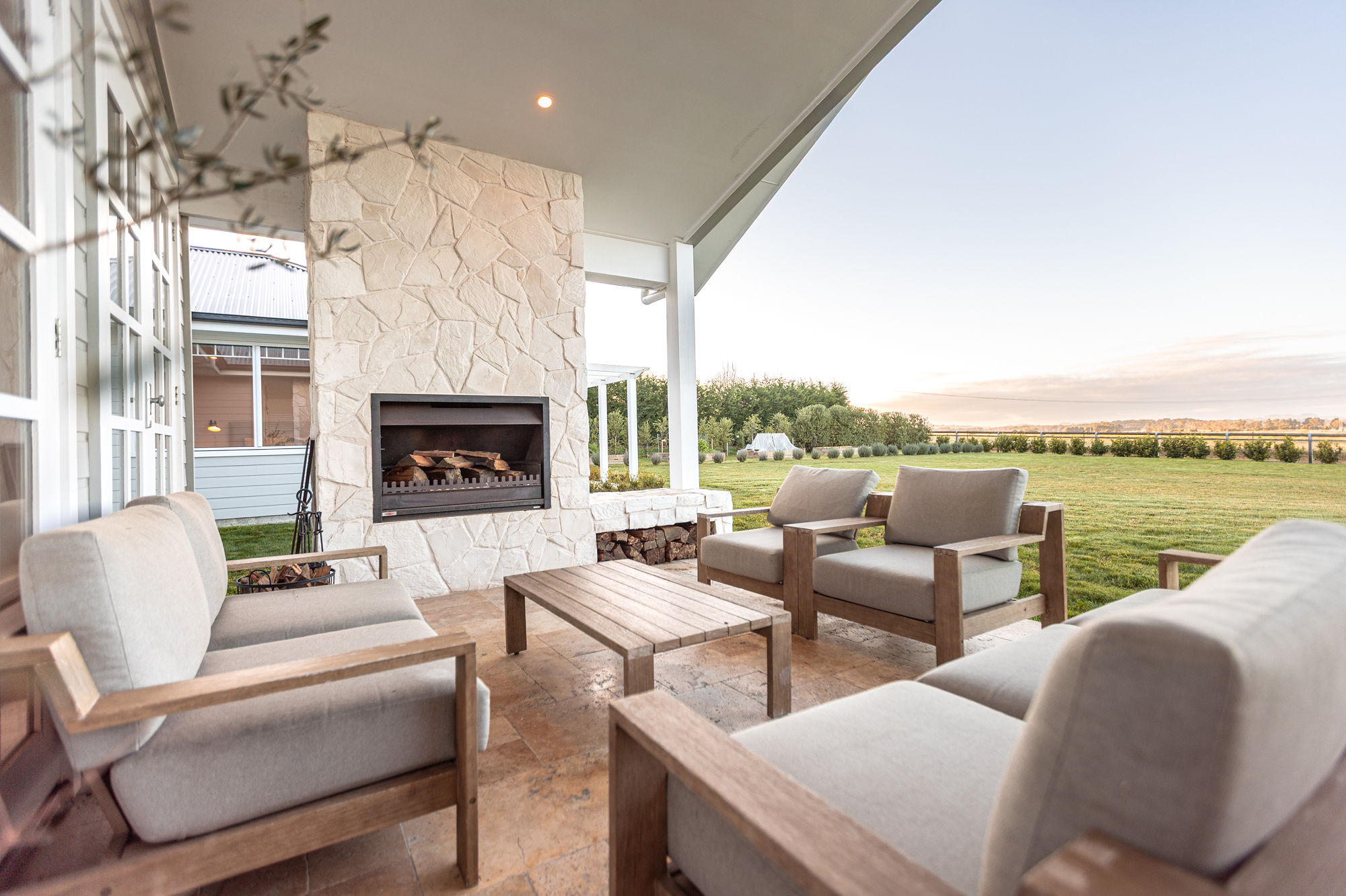 The covered terrace at Birchgrove, an open fire and views over the fields.